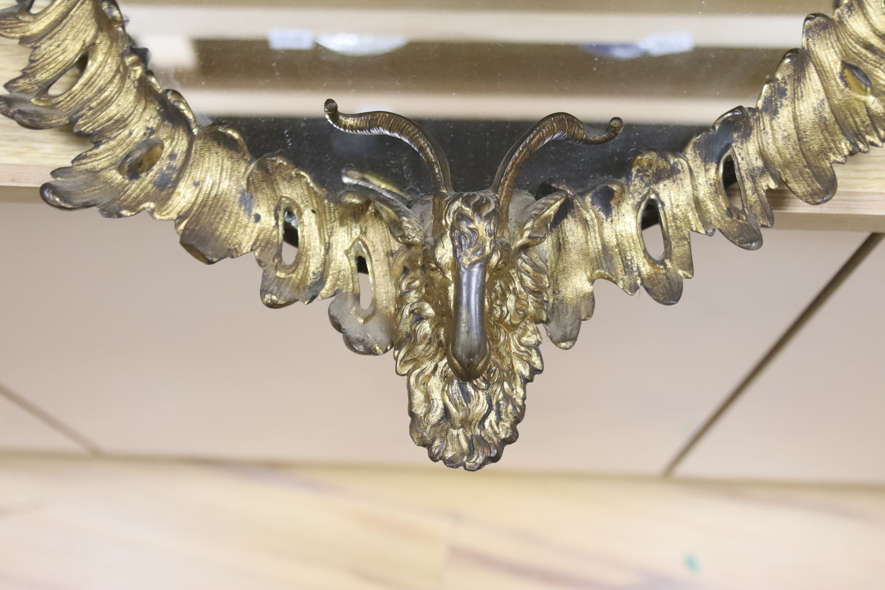 An Adam revival ormolu goat's heads wall mirror, length 60cm